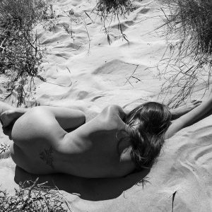 corps de femme allongée nue sur le sable